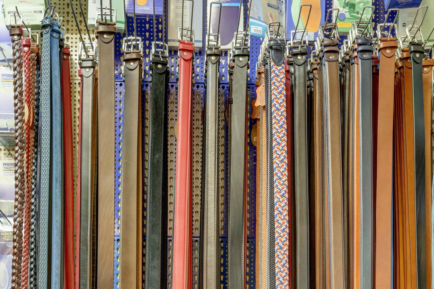 Cinture in cuoio di colori diversi appese all'espositore